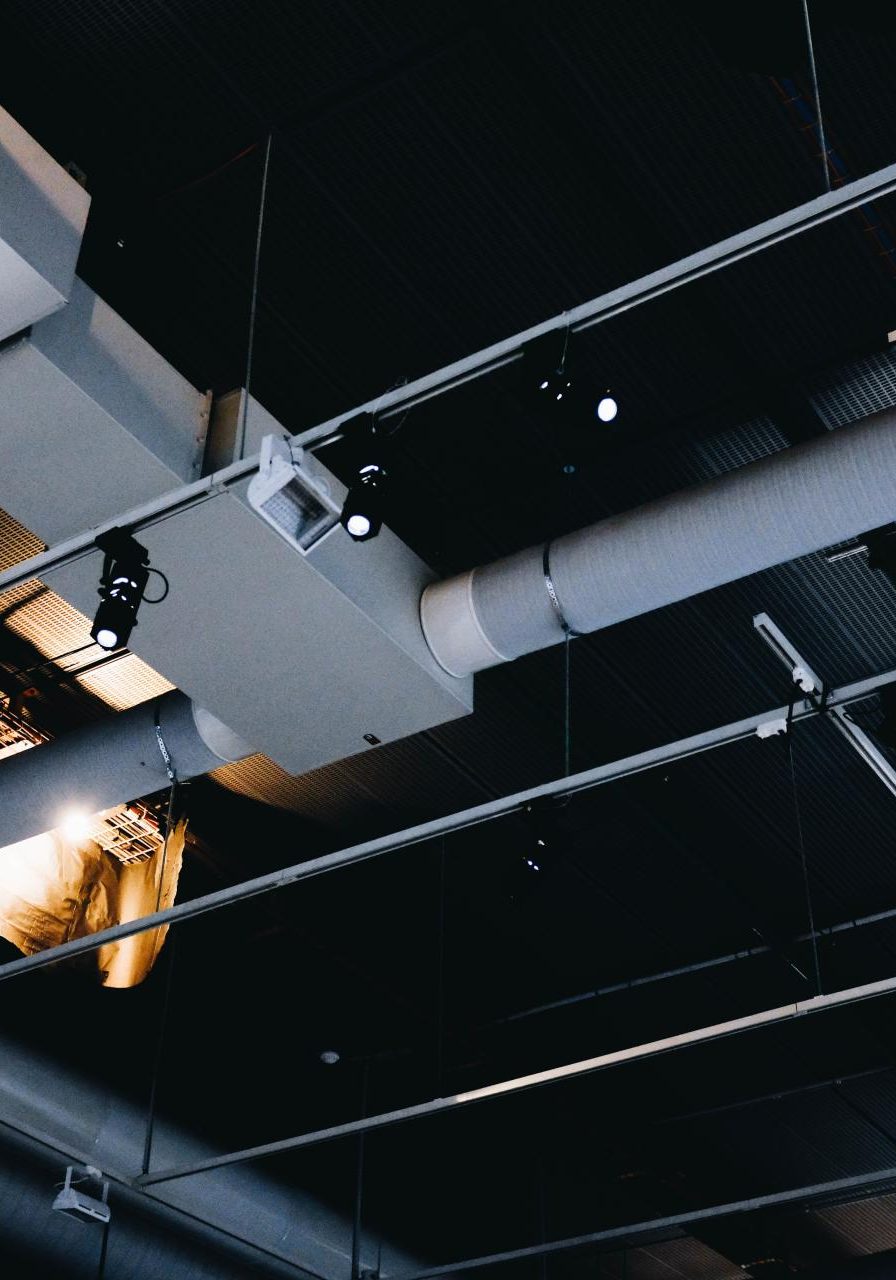 low-angle-shot-metal-black-ceiling-with-white-ventilation-pipes